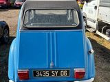 a small blue car that is parked in a parking lot