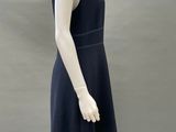 mannequin dressed in a black dress and hat on a mannequin stand