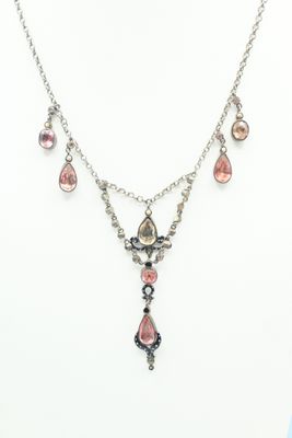 a necklace and earring set with pink stones on a mannequin