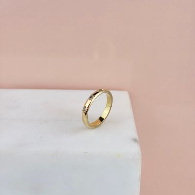 une bague en or posée sur un bloc de marbre
