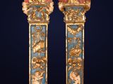 pair of gold and blue painted columns with figures on them