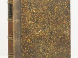 an old book sitting on top of a white surface