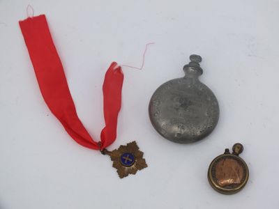 trois médailles et un ruban rouge sur un fond blanc
