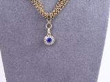 a gold chain necklace with a blue stone pendant on it
