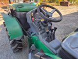 a green tractor that is parked on the side of the road