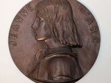 une vieille médaille en bronze sur laquelle est représenté le visage d'un homme