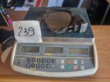 une calculatrice posée sur un bureau, avec une étiquette de prix dessus