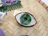 a green eye shaped object sitting on a table next to a comb