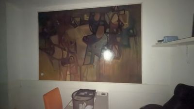 a painting on the wall above a microwave and a chair in a room