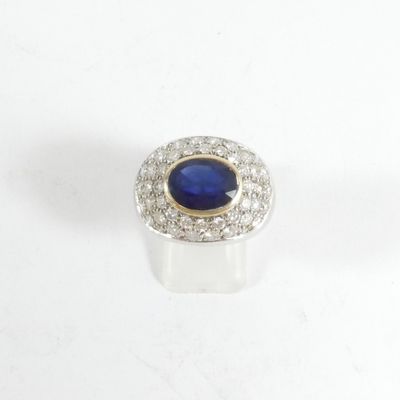 gros plan d'une bague avec une pierre bleue entourée de diamants