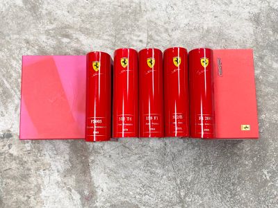 une rangée de rouges à lèvres rouge Ferrari posés sur une boîte rose
