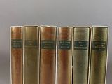 five books are lined up in a row on a table