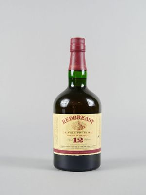 gros plan d'une bouteille de whisky sur une surface blanche