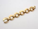 a close up of a gold chain bracelet on a white surface