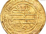 a close up of a gold coin with arabic writing on it