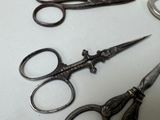 three pairs of scissors and a pair of scissors on a table