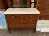 une commode avec un plateau en marbre et des tiroirs, dans une pièce