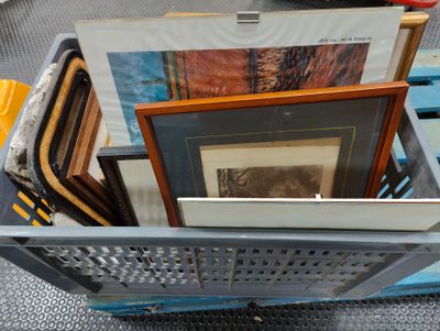 un panier rempli de photos encadrées posé par terre