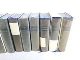 several books are lined up in a row on a white surface