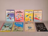 several children ' s books are lined up on a white surface
