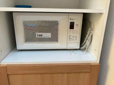 un micro-ondes posé sur un meuble dans une pièce