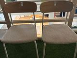 pair of chairs in front of a window with grass on the ground