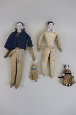 trois poupées assises sur le mur