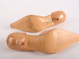 pair of nude colored shoes on a white surface with a white background