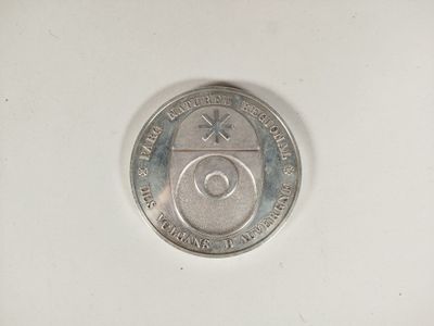 l'image d'une pièce de monnaie posée sur une surface blanche