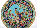 a colorful plate with a bird on it on a stand