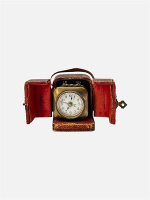 une petite horloge posée dans un écrin rouge