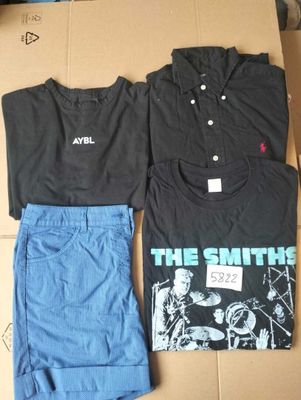 two shirts and a pair of shorts sitting on a cardboard box