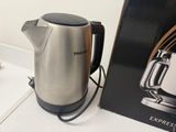 a coffee pot sitting next to a box on a table