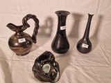 trois vases posés sur une table, sur fond blanc
