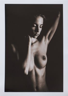 a black and white photo of a naked woman with her hands behind her head
