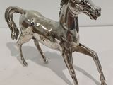 une figurine de cheval en argent posée sur une table