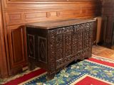 a wooden chest in the middle of a room with wood paneled walls