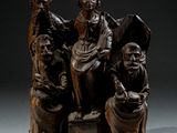 une photo représentant une statue d'une femme assise sur un banc en compagnie de trois hommes