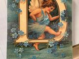 a card with a picture of an angel holding a letter d
