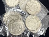 plusieurs pièces d'argent dans des sachets en plastique posées sur une surface noire