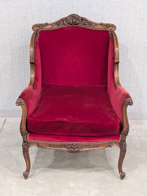 une chaise rouge posée sur un sol blanc, près d'un mur