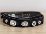 black leather dog collar with crystal studs on a wooden table