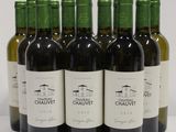 six bottles of wine are lined up in a row on a white surface