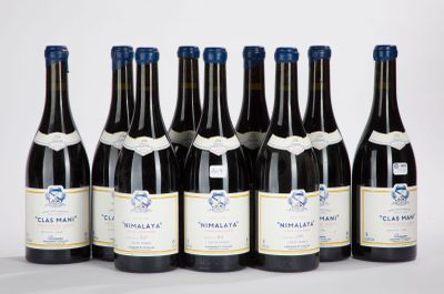 six bottles of wine are lined up in a row on a white surface