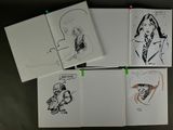 several drawings of a woman in a suit and tie are on a table
