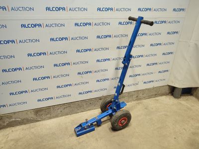a blue hand truck that is parked in front of a wall
