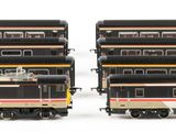several model trains are lined up in a row on a white surface