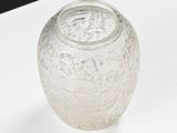 a clear glass vase with a lid on a table