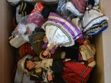 a cardboard box filled with dolls and other items