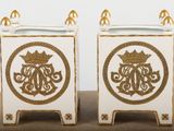 two white and gold vases sitting on top of a table